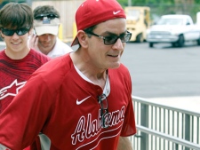In this May 2, 2011 file photo, actor Charlie Sheen helps carry coolers full of food for a benefit baseball game and concert in Tuscaloosa, Ala., for victims of the tornadoes that swept through the area on April 27. Sheen donated $25,000 around the beginning of December to help tornado relief in Alabama, making good on a promise to help survivors of the deadly twisters. (AP Photo/Butch Dill, File)