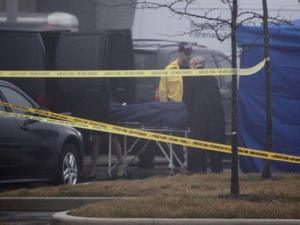 A body is carried away from a crime scene outside an Oakville police station on Oak Walk Drive on Jan. 12, 2012.