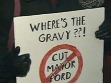 A protester hold up a sign outside city hall during a demonstration Tuesday night. 