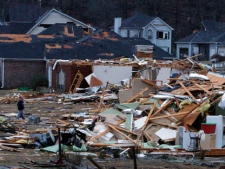 Residents walk around through debris after a possible tornado ripped through the Trussville, Ala., area in the early hours of Monday, Jan. 23, 2012. (AP Photo/Butch Dill)