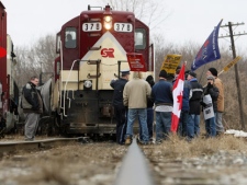 Ontario Provincial Police arrive as CAW union members block an Electro-Motive, Caterpiller-made locomotive in Ingersoll, Ont., on Wednesday, Jan. 25, 2012. Electro-Motive workers have been locked out since Jan. 1, 2012. (THE CANADIAN PRESS/Dave Chidley)