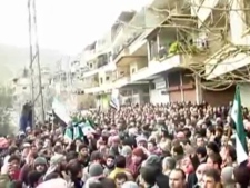 This image from amateur video made available by the Ugarit News group and shot on Sunday, Jan. 29, 2012, purports to show a funeral in Damascus, Syria. The Syrian military launched an offensive to regain control of suburbs on the eastern edge of Damascus on Sunday, storming neighborhoods and clashing with groups of army defectors in fierce fighting that sent residents fleeing and killed at several people, activists said. (AP Photo/Ugarit News Group via APTN)
