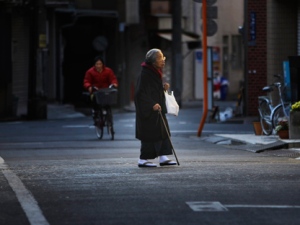 In this Jan. 22, 2011, file photo, a kimono-clad elderly woman walks across a street in Tokyo. Japan's rapid aging means the national population of 128 million will shrink by one-third by 2060 and seniors will account for 40 percent of people, the country estimates. (AP Photo/Junji Kurokawa, File)