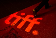 A man walks on a red carpet displaying a sign for the Toronto International Film Festival at the TIFF Bell Lightbox in Toronto on Wednesday, Sept. 3, 2014. (The Canadian Press/Darren Calabrese)