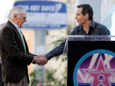 Comic book creator Stan Lee, left, gets a handshake from Todd McFarlane, creator of the comic book "Spawn" and founder of MacFarlane Toys, before Lee received a star on the Hollywood Walk of Fame in Los Angeles on Tuesday, Jan. 4, 2011. (AP Photo/Chris Pizzello)