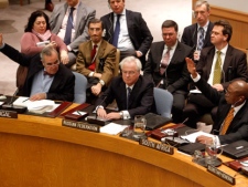 Portuguese representative Jose Filipe Moraes Cabral, left, and South African representative Baso Sangqu, right, glance at Russian representative Vitaly Churkin, center, as they vote in support of a draft resolution backing an Arab League call for Syrian President Bashar Assad to step down, which was later vetoed by Russia and China, during a meeting of the United Nations Security Council at United Nations headquarters on Saturday, Feb. 4, 2012. The unusual weekend session comes as Syrian forces pummel the city of Homs with mortars and artillery in what activists are calling one of the bloodiest episodes of the uprising. (AP Photo/Mary Altaffer)