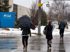 Unidentified people walk past part of the Research in Motion (RIM)campus in Waterloo, Ontario on Monday January 23, 2012. THE CANADIAN PRESS/Chris Young