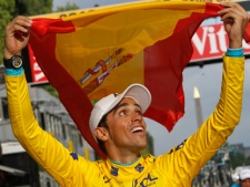 In this July 25, 2010, file photo, three-time Tour de France winner Alberto Contador of Spain holds the Spanish national flag during a victory lap after winning the Tour de France cycling race in Paris. (AP Photo/Christophe Ena, File)