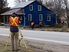 Surveyors measure at the crash scene in Hampstead, Ont., on Tuesday, Feb. 7 2012, where a van and truck collision killing 11 people on Monday. (THE CANADIAN PRESS/ Frank Gunn)