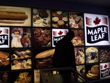A Maple Leaf Foods employee walks past a Maple Leaf sign at the company's meat facility in Toronto on Monday, Dec. 15, 2008. (THE CANADIAN PRESS/Nathan Denette)
