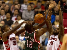 Milwaukee Bucks forward Luc Mbah A Moute (12) runs into stiff defence from Toronto Raptors forwards Ed Davis (left) and Amir Johnson (right) during first half NBA action in Toronto on Wednesday, Feb. 8, 2012. (THE CANADIAN PRESS/Frank Gunn)