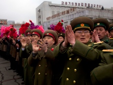 North Korean military members cheer during the unveiling of a new bronze statue depicting the late leader Kim Jong Il and his father Kim Il Sung at Mansudae Art Studio in Pyongyang on Tuesday, Feb. 14, 2012. (AP Photo/David Guttenfelder)