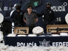 Federal police agents present Jaime Herrera, alias "El Viejito," alleged member of the Pacific drug cartel, to the press in Mexico City, on Tuesday, Feb. 14, 2012. Herrera is considered to be one of the most important producers and distributors of synthetic drugs, according to authorities. (AP Photo/Alexandre Meneghini)