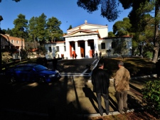 Onlookers and police gather outside the antiquities museum in Olympia, Greece, where two masked armed robbers tied up a guard and made off with dozens of artifacts Friday, Feb. 17, 2012. (AP Photo/Dimitris Papaioannou)