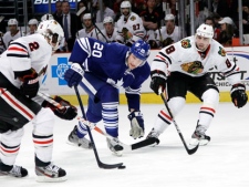 Toronto Maple Leafs center David Steckel (20) tries to get control of the puck as Chicago Blackhawks defenseman Duncan Keith (2) and Nick Leddy defend during the first period of an NHL hockey game on Wednesday, Feb. 29, 2012, in Chicago. (AP Photo/Charles Rex Arbogast)