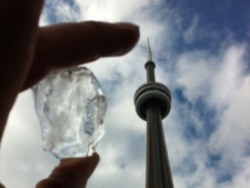 CP24 camera operator Matthew Reid holds up a chunk of ice that has fallen from the CN Tower on March 1, 2012.
