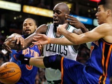 Boston Celtics' Kevin Garnett, center, competes with New York Knicks' Tyson Chandler, left, and Jeremy Lin, right, for a loose ball in the second quarter of an NBA basketball game in Boston, Sunday, March 4, 2012. (AP Photo/Michael Dwyer)