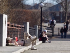 Steven Anderson reads a book and enjoys the sunshine on a bridge at Cedarvale Park in Toronto on Sunday, March 11, 2012. The temperature reached 17C, breaking the old record for this date of 15.3C. THE CANADIAN PRESS/Pawel Dwulit