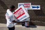 A volunteer carries sign boards outside the campaign offices before Toronto mayoral candidate Doug Ford starts his campaign by door knocking in his local Etobicoke neighbourhood of Toronto on Saturday, September 20, 2014. THE CANADIAN PRESS/Chris Young
