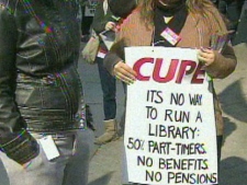 A protester attending a public library workers rally Wednesday afternoon shows off her sign. (CP24)