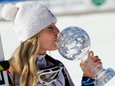 Lindsey Vonn, of the United States, kisses the trophy of the alpine ski, women's World Cup downhill discipline title, in Schladming, Austria, Wednesday, March 14, 2012. (AP Photo/Armando Trovati)