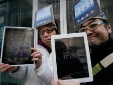 Ryota Musha, 41, right, and Hisanori Kogure, 31, show off new iPad tablet computers they purchased in Tokyo on Friday, March 16, 2012. Sales of the third version of Apple's iPad began Friday. (AP Photo/Koji Sasahara)