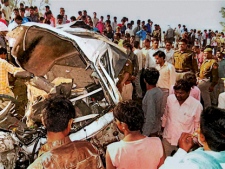Indian police officers and locals gather near the wreckage of a vehicle in Hathras, India, Tuesday, March 20, 2012. Police said over a dozen people died when a moving train collided with an overcrowded taxi at an unmanned railroad crossing in the northern Indian state of Uttar Pradesh. (AP Photo)