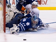 Toronto Maple Leafs goaltender James Reimer clears the puck as New York Islanders Casey Cizikas, 53, looks on during first period NHL hockey action in Toronto on Tuesday, March 20, 2012. (THE CANADIAN PRESS/Chris Young)