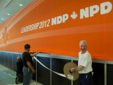 Workers put NDP banners up as they get ready for their party's leadership convention in Toronto on Thursday, March 22, 2012. (THE CANADIAN PRESS/Nathan Denette)
