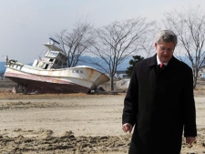 Prime Minister Stephen Harper visits the coastal region near Sendai, Japan on Monday, March 26, 2012. The area was heavily impacted by the March 11, 2011, earthquake and tsunami. A boat that was washed one kilometre inland is seen in the background. (AP Photo/The Canadian Press, Sean Kilpatrick)