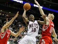 New Jersey Nets guard Ben Uzoh (18) takes a shot against Houston Rockets forwards Luis Scola (4) and Chase Budinger (10) in the second quarter of an NBA basketball game, Tuesday, March 29, 2011, in Newark, N.J. (AP Photo/Julio Cortez)