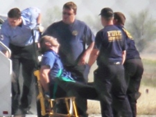 Emergency workers tend to a JetBlue captain who had a "medical situation" during a Las Vegas-bound flight from JFK airport, Tuesday, March 27, 2012. The plane was diverted and landed in Amarillo, Texas. Passengers said the pilot screamed that Iraq or Afghanistan had planted a bomb on the flight, and he was locked out of the cockpit and then tackled and restrained by passengers. (AP Photo/Steve Douglas)