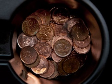 A handful of one cent coins is seen in a passenger car cupholder in Dartmouth, N.S, on Thursday, March 29, 2011. The federal budget has announced the Royal Canadian Mint will stop making pennies this fall, saving 11-million dollars a year. Pennies will still be legal tender until they slowly vanish from circulation. THE CANADIAN PRESS/Andrew Vaughan