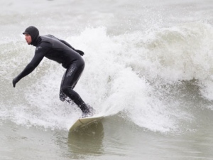 A surfer rides the waves on Lake Ontario at the Scarborough Bluffs on March 31, 2012. (Sandie Benitah/CP24)