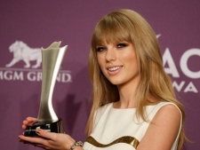 Taylor Swift poses backstage with the award for entertainer of the year at the 47th Annual Academy of Country Music Awards on Sunday, April 1, 2012, in Las Vegas. (AP Photo/Isaac Brekken)