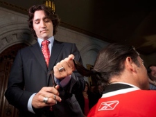 Liberal MP Justin Trudeau trims the end of Conservative Senator Patrick Brazeau's pony tail out of respect in the Foyer of the House of Commons on Parliament Hill Ottawa, Monday April 2, 2012. THE CANADIAN PRESS/Adrian Wyld