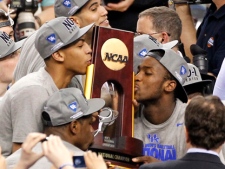 Kentucky forward Anthony Davis, left, and forward Michael Kidd-Gilchrist, right, kiss the trophy after winning the NCAA men's college basketball championship game Tuesday, April 3, 2012, in New Orleans. Kentucky beat Kansas 67-59. (AP Photo/Bill Haber) 