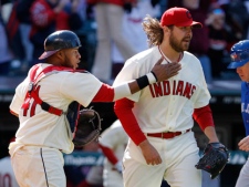 Cleveland Indians catcher Carlos Santana congratulates relief pitcher Chris Perez after he got Toronto Blue Jays' Jose Bautista to fly out for the final out in the Indians' 4-3 win in a baseball game in Cleveland on Sunday, April 8, 2012. (AP Photo/Amy Sancetta)