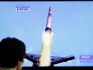 A South Korean woman watches a TV news report showing a computer generated image of North Korea's long-range rocket at Seoul train station in Seoul, South Korea on Friday, April 13, 2012. North Korea fired a long-range rocket early Friday, South Korean and U.S. officials said, defying international warnings against moving forward with a launch widely seen as a provocation. (AP Photo/Lee Jin-man)