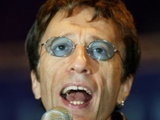 This Saturday, Sept. 25, 2004, file photo shows former Bee Gees singer Robin Gibb, performing a song at the beginning of a show match between former German tennis star Steffi Graf and Argentina's Gabriela Sabatini at the Max-Schmeling-Halle hall on in Berlin. British media reports said Saturday April 14, 2012 former Bee Gee Robin Gibb is gravely ill with pneumonia in a London hospital. The Sun newspaper reported Saturday that 62-year-old Gibb is in a coma, citing a family friend.(AP Photo/ Jan Bauer)