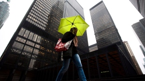 A pedestrian shields herself from rain under an umbrella in downtown Toronto Friday, March 4, 2011. THE CANADIAN PRESS/Darren Calabrese