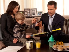 Ontario Premier Dalton McGuinty reads a books with two-and-a-half-year-old Rowan Henderson as his mother Naomi looks on in Ottawa on Friday, March 30, 2012. (THE CANADIAN PRESS/Adrian Wyld)
