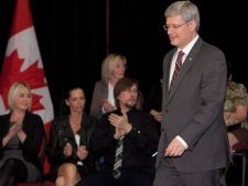 Prime Minister Stephen Harper walks in front of parents of victims of crimes after he announced a new income support program Friday, April 20, 2012 in Sherbrooke, Que. Parents of victims Isabelle Gaston, from the left, Edith Touchette and Stephane Luce applaud. THE CANADIAN PRESS/Jacques Boissinot