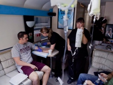 Emergency medical technician Debra Lund prepares to hang an IV bag as co-worker Stacey Kreitlow inserts an IV catheter into the arm of a patient aboard the Hangover Heaven bus in Las Vegas on Sunday, April 15, 2012. The bus picked up 16 patients on its first weekend as a mobile treatment centre for tourists who spent the night drinking in all the nightlife Las Vegas has to offer. For a fee, they get a quick morning-after way to rehydrate, rejuvenate and resume their revelry. (AP Photo/Julie Jacobson) 