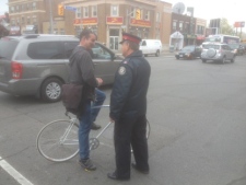 Toronto police Sgt. Jack West speaks to a cyclist during a road safety blitz on Danforth Avenue on Thursday, April 26, 2012. (CP24/Cam Woolley)