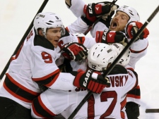 New Jersey Devils' Zach Parise (9), Alexei Poonikarovsky (12), Marek Zidlicky (2) and David Clarkson, top right, mob Adam Henrique, obscured, after he scored during the second overtime against the Florida Panthers in Game 7 of a first-round NHL Stanley Cup playoff hockey series in Sunrise, Fla., Wednesday, April 26, 2012. The Devils won 3-2. (AP Photo/J Pat Carter)