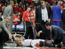 Chicago Bulls guard Derrick Rose (1) is helped by trainers after an injury during the fourth quarter of  Game 1 in the first round of the NBA basketball playoffs against the Philadelphia 76ers in Chicago, Saturday, April 28, 2012. The Bulls won 103-91. (AP Photo/Nam Y. Huh)