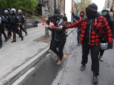 Protesters taunt police with donuts on a string during an anti-capitalism rally in Montreal on Tuesday, May 1, 2012. (THE CANADIAN PRESS/Ryan Remiorz)