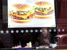 In this photo taken Monday, April 30, 2012, a woman eats a meal inside a McDonald's fast food restaurant in London. (AP Photo/Alastair Grant)