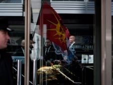 Security guards stand behind a glass door while Occupy Toronto protesters gather outside the Metro Convention Centre, the venue for Barrick Gold's AGM in Toronto on Wednesday, May 2, 2012. (THE CANADIAN PRESS/Chris Young)